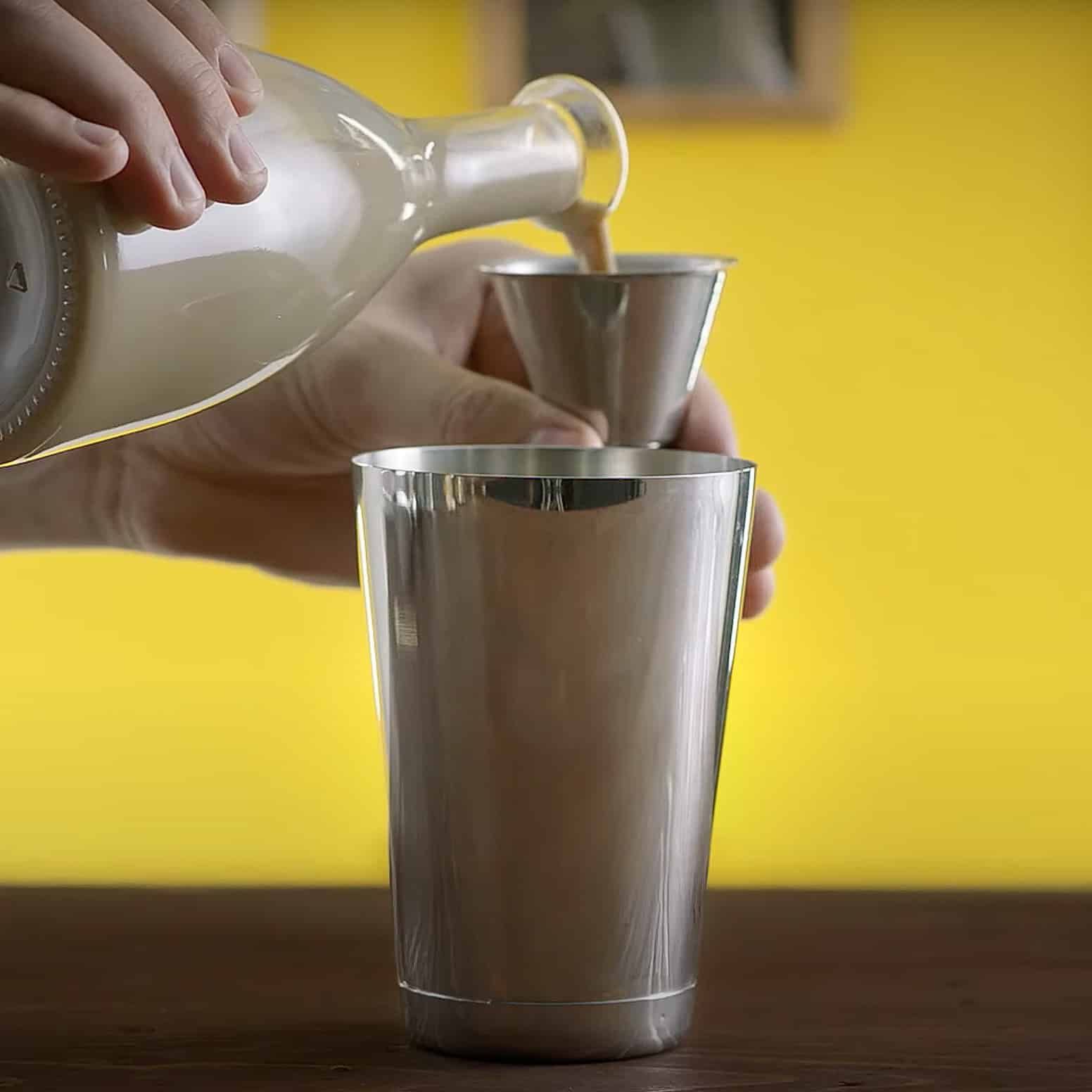 Irish cream liqueur being poured into shaker
