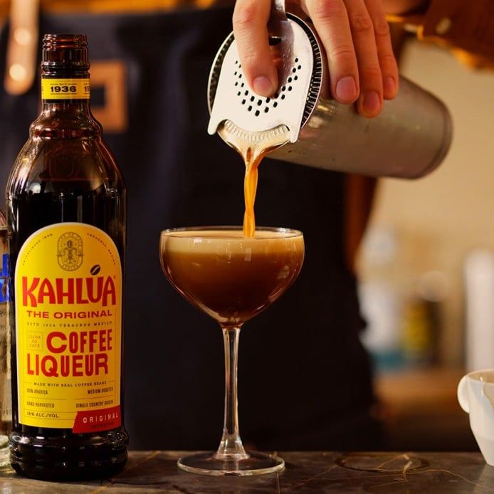 Cocktail being strained into glass