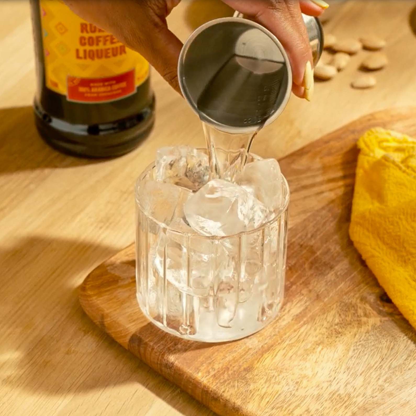 Vodka being poured into a rocks glass with ice