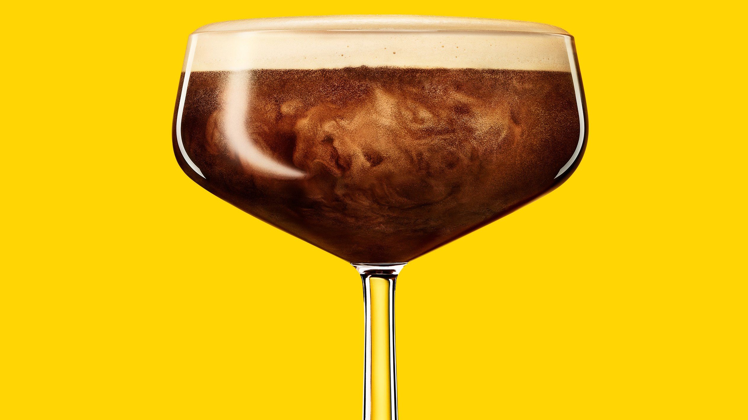 One Salted caramel espresso martini in a martini glass in front of a yellow background