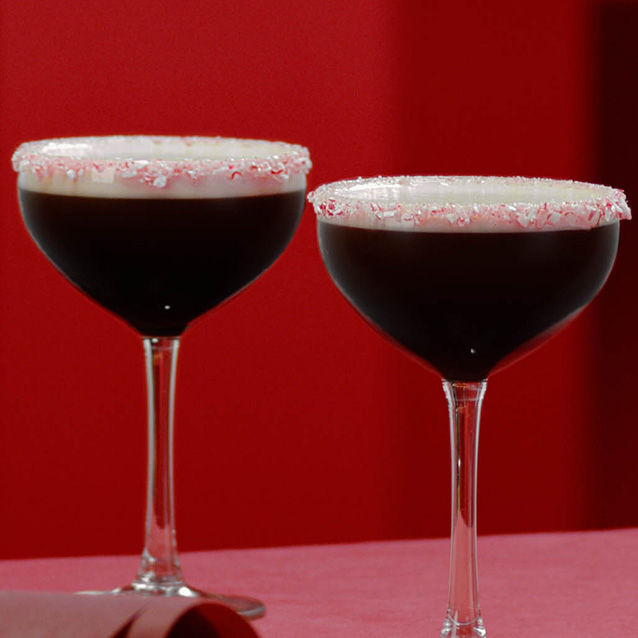 2 peppermint espresso martini cocktails against a festive red background