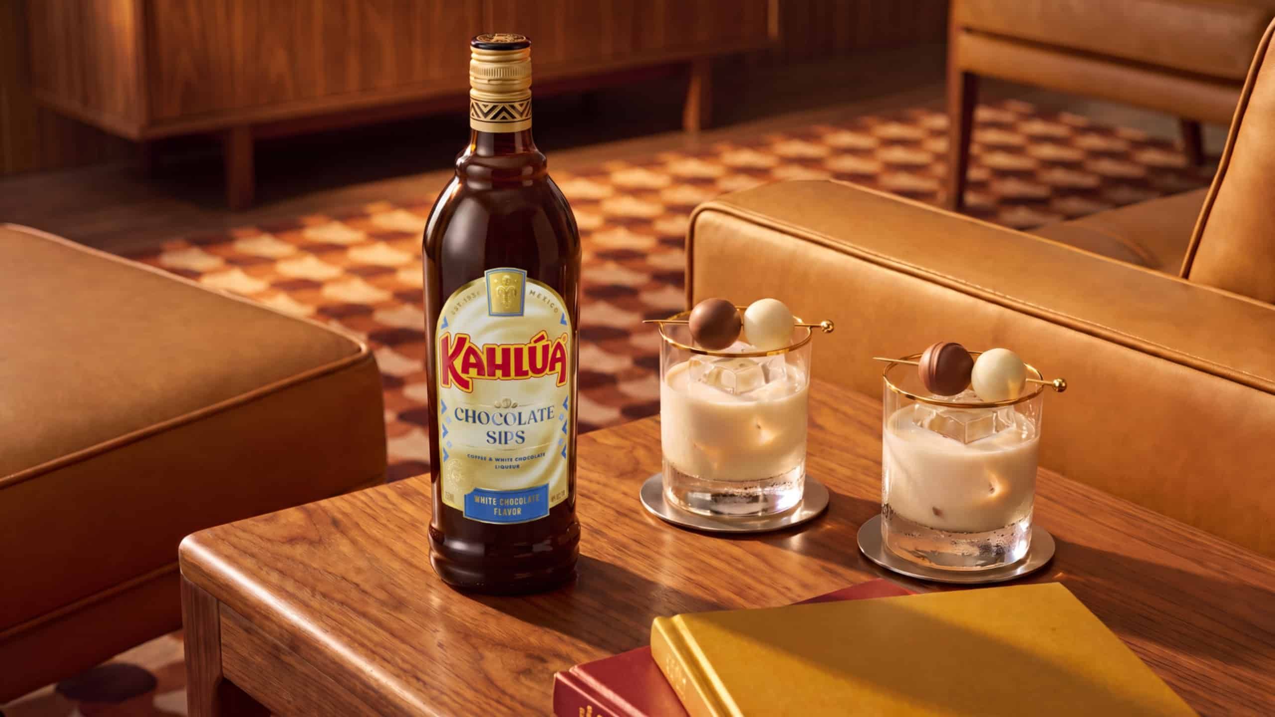 Chocolate sips white chocolate bottle and a neat drink on a table