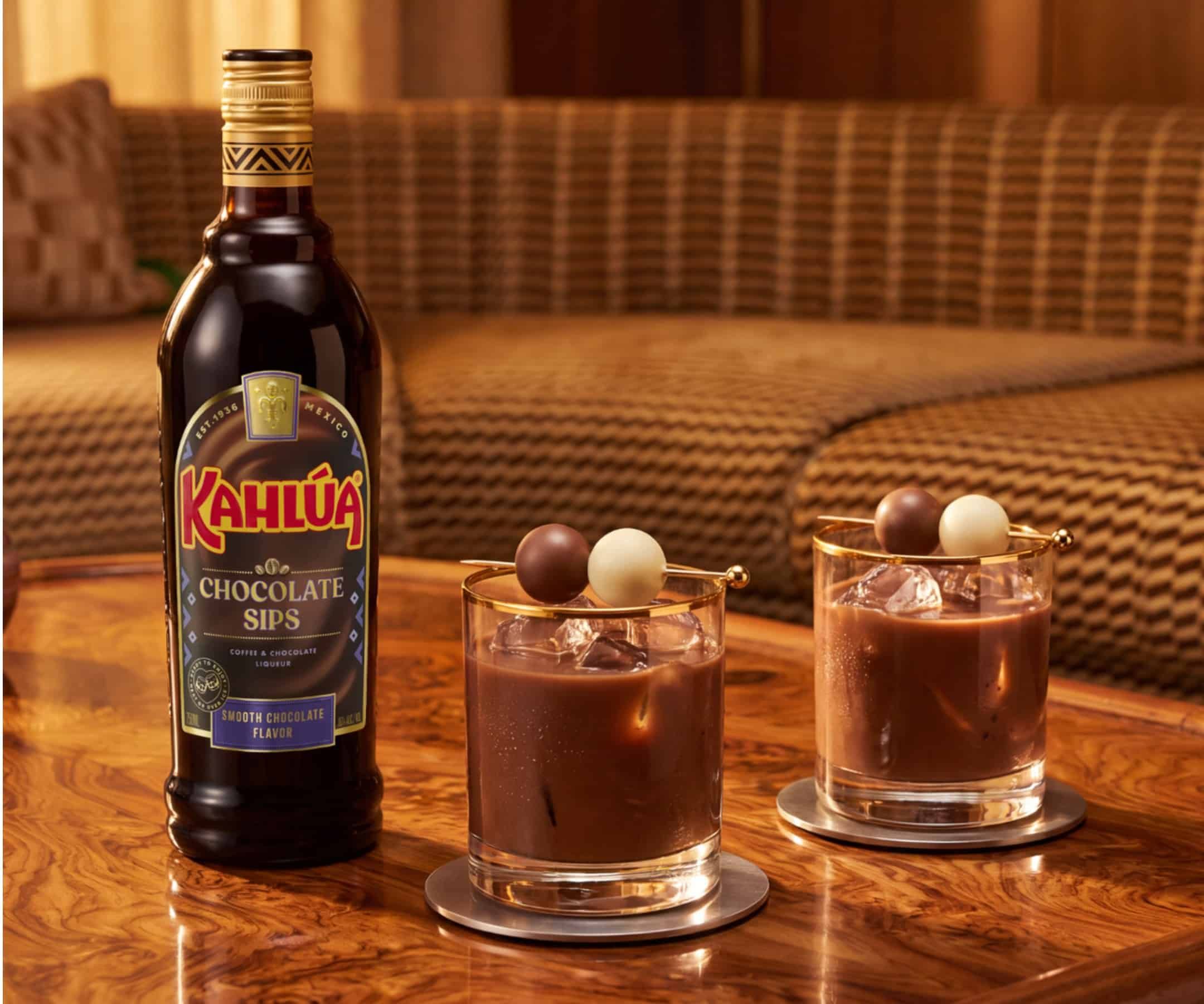 Kahlua Chocolate Sips bottle on table with two neat drinks