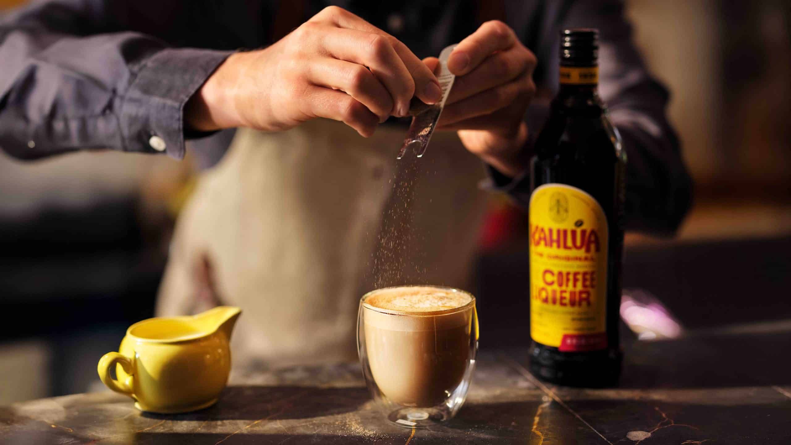 Bartender garnishing a Kahlua cappuccino at a bar