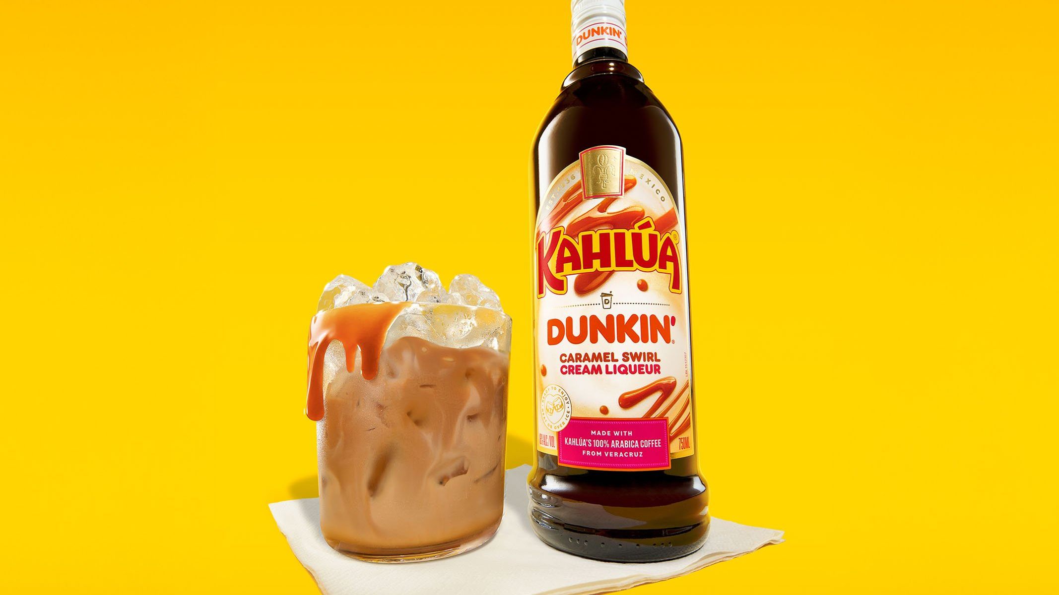 Dunkin' Kahlúa Caramel Swirl Cream liqueur next to a drink over ice